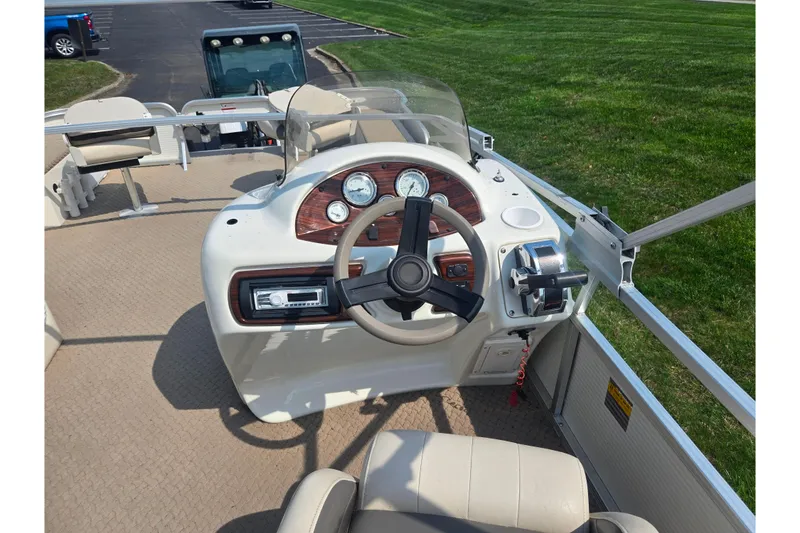 Slide: The Image of Steering console of a 2006 Suncruiser Trinidad 220 pontoon boat, featuring gauges and controls. - 23