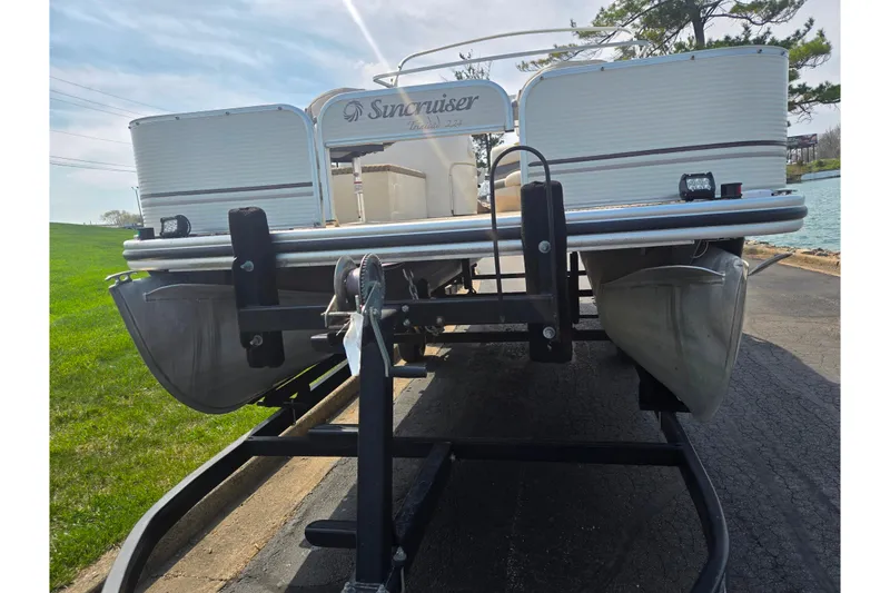 Slide: The Image of 2006 Suncruiser Trinidad 220 pontoon boat on trailer, parked near a lake. - 6