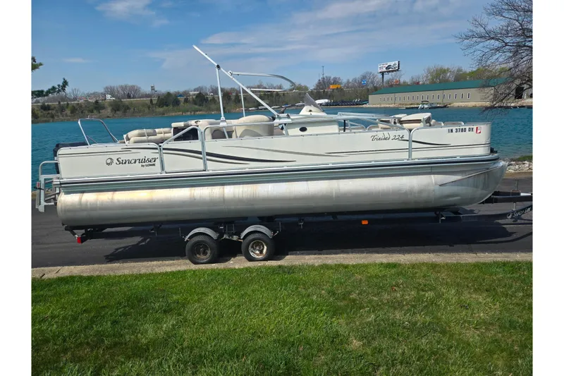 Slide: The Image of 2006 Suncruiser Trinidad 220 pontoon boat on trailer by a lake. - 9