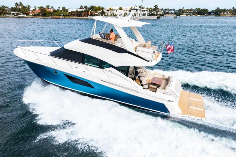 The Image of 2015 Tiara Yachts cruising on water, featuring sleek design and American flag. - 0