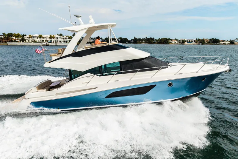 Slide: The Image of 2015 Tiara Yachts cruising on water, showcasing sleek design and luxury features. - 2