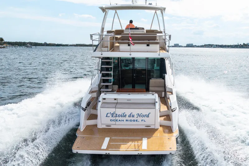 Slide: The Image of 2015 Tiara Yachts cruising on water, rear view with "L'Étoile du Nord" nameplate. - 3