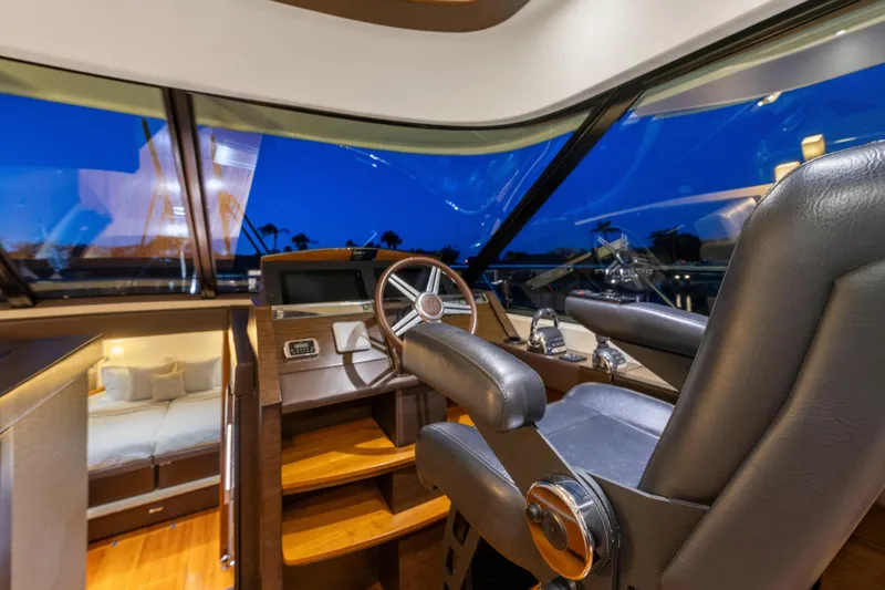 Slide: The Image of 2015 Tiara Yachts helm with luxurious interior and panoramic windows at dusk. - 30