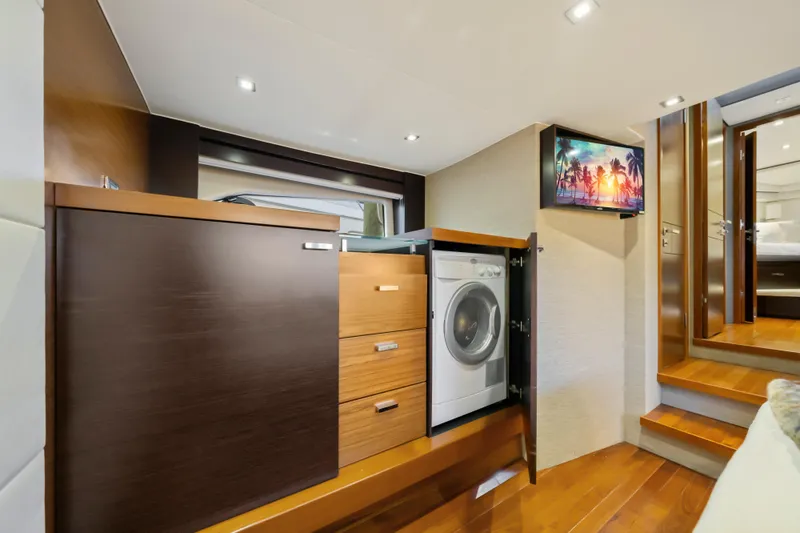 Slide: The Image of Interior of 2015 Tiara Yacht featuring a washing machine, wooden cabinetry, and mounted TV. - 31
