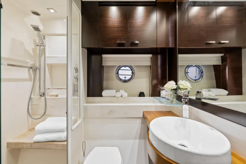 Slide: The Image of Luxurious 2015 Tiara Yachts bathroom with modern fixtures, elegant wood cabinetry, and a round porthole window. - 34