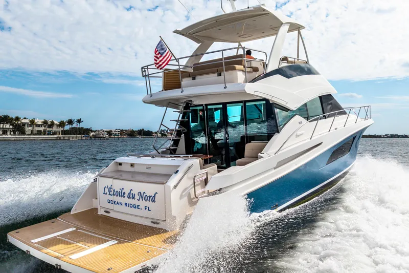 Slide: The Image of 2015 Tiara Yachts cruising in Ocean Ridge, FL, with American flag and luxury design. - 4