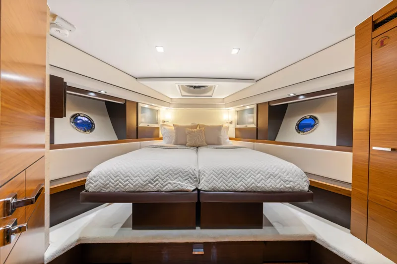 Slide: The Image of Luxurious 2015 Tiara Yachts bedroom interior with elegant bedding and porthole windows. - 45