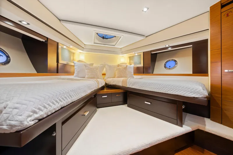 Slide: The Image of Luxurious 2015 Tiara Yachts cabin interior with twin beds and elegant wood finishes. - 47