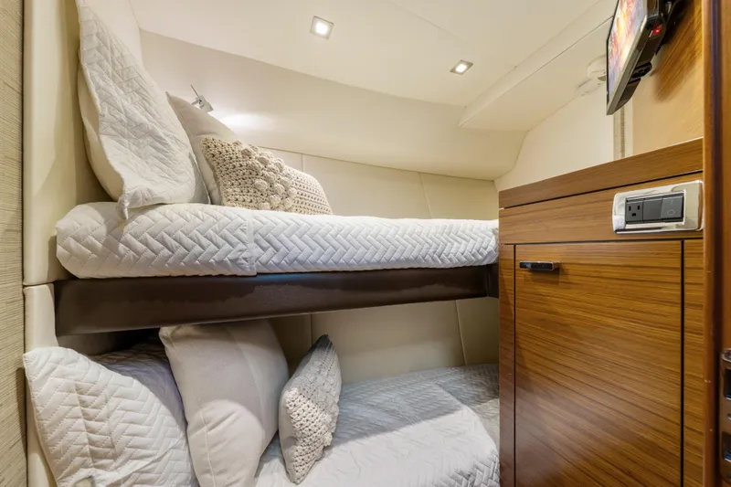 Slide: The Image of 2015 Tiara Yachts interior with cozy bunk beds and wooden cabinetry. - 49