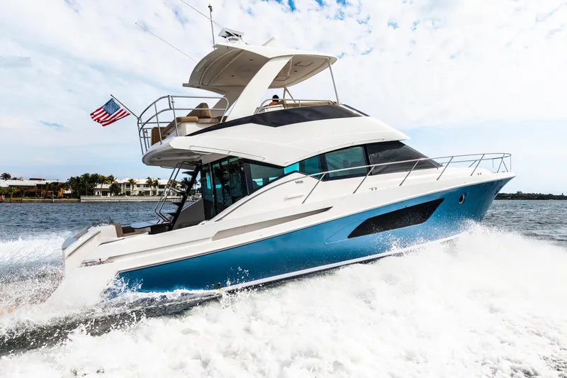Slide: The Image of 2015 Tiara Yachts cruising on water, displaying sleek design and American flag. - 5