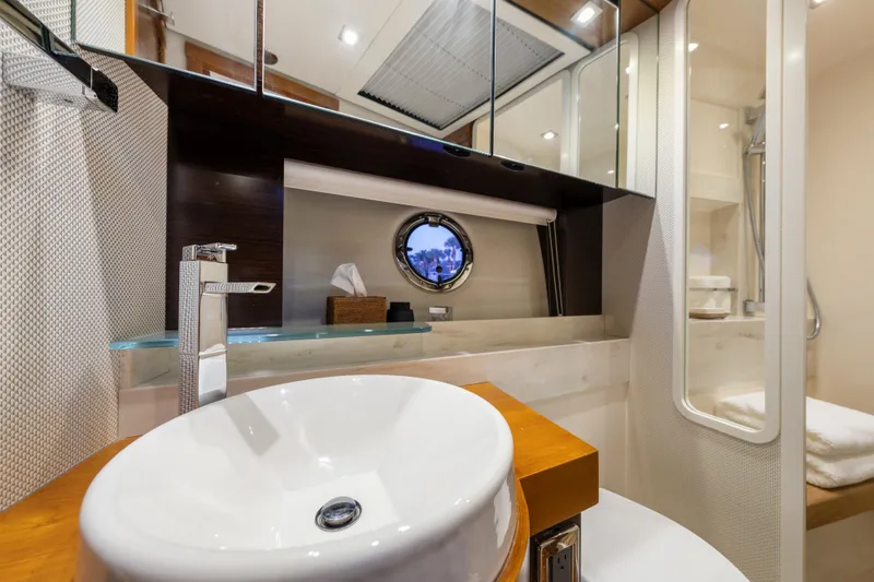Slide: The Image of Luxurious 2015 Tiara Yachts bathroom with modern sink, mirror, and porthole window. - 52