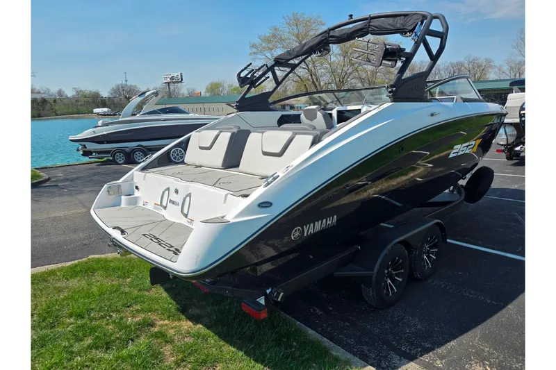 Slide: The Image of 2023 Yamaha Boats 252XE on trailer by a lake, showcasing sleek design and modern features. - 1