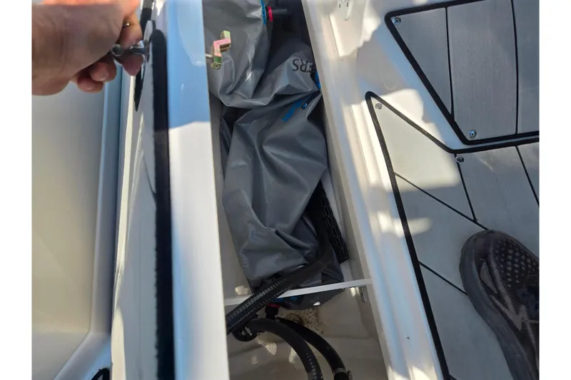 Slide: The Image of 2023 Yamaha Boats 252XE storage compartment with equipment and flooring detail. - 14