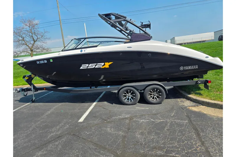 Slide: The Image of 2023 Yamaha Boats 252XE on trailer, black and white design, parked outdoors. - 4