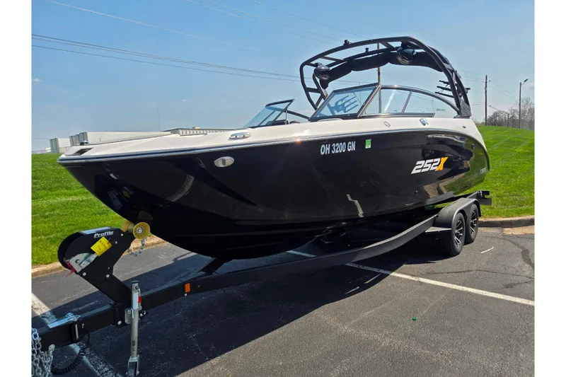 Slide: The Image of 2023 Yamaha Boats 252XE on trailer, sleek black design, parked outdoors. - 5