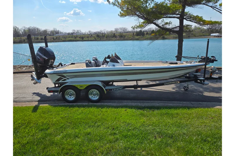 Slide: The Image of 2016 Legend Alpha 211R DC boat on trailer by a scenic lake. - 10