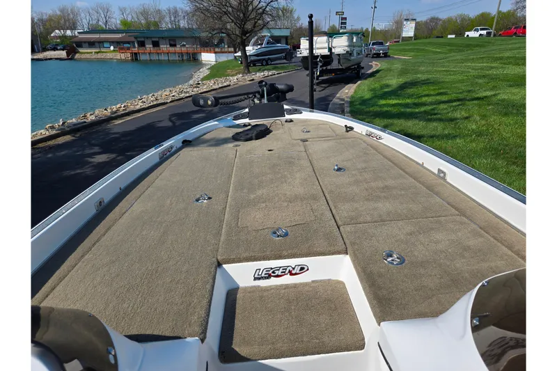 Slide: The Image of 2016 Legend Alpha 211R DC boat docked by a scenic lakeside with grassy surroundings. - 15