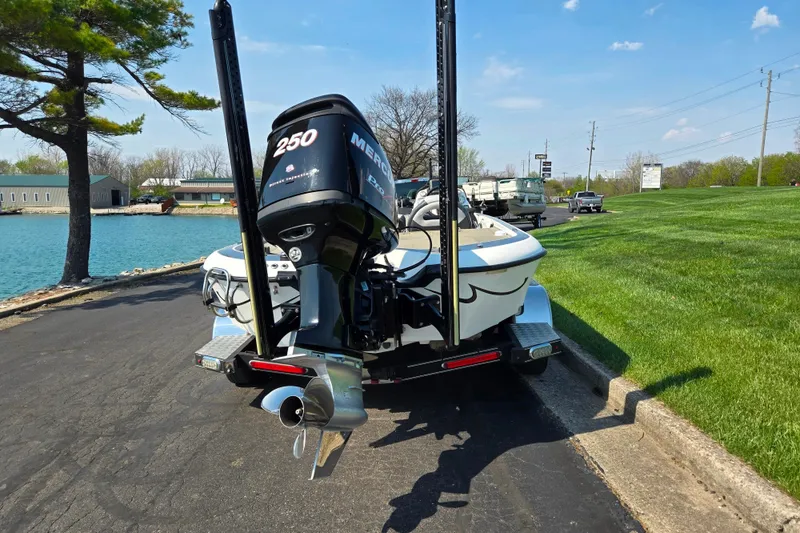 Slide: The Image of 2016 Legend Alpha 211R DC boat with Mercury 250 engine on a trailer by a lake. - 2