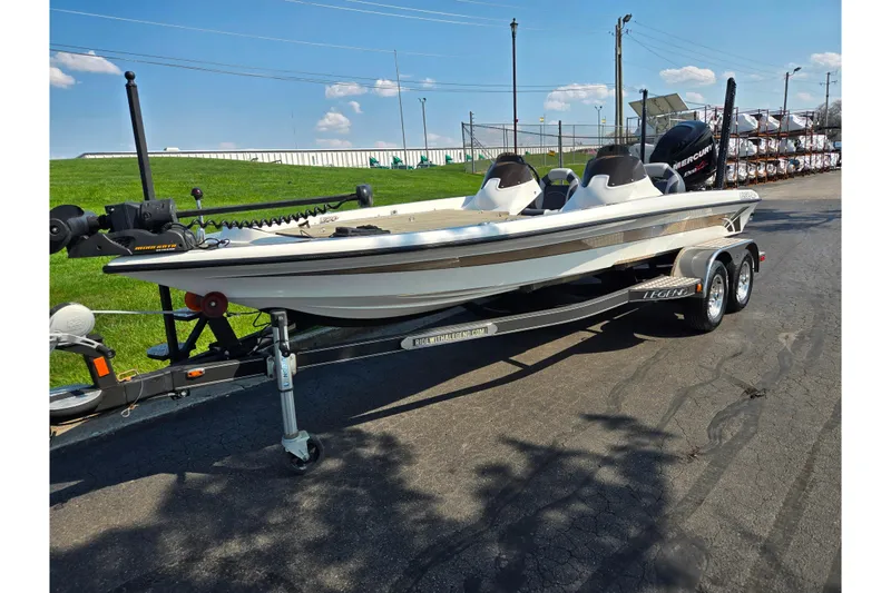 Slide: The Image of 2016 Legend Alpha 211R DC boat on trailer, parked outdoors under clear sky. - 5