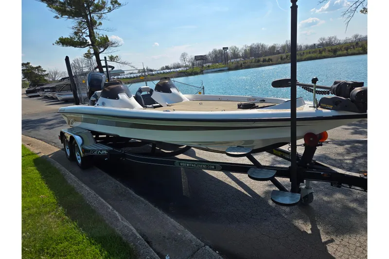 Slide: The Image of 2016 Legend Alpha 211R DC boat on trailer by a scenic lake. - 9