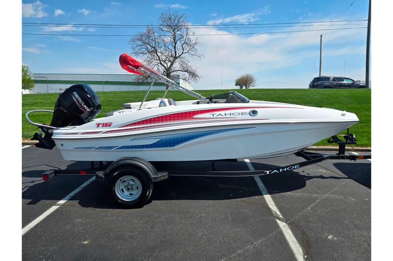 Slide: The Image of 2024 Tahoe T16 boat on trailer, parked outdoors under a clear blue sky. - 4
