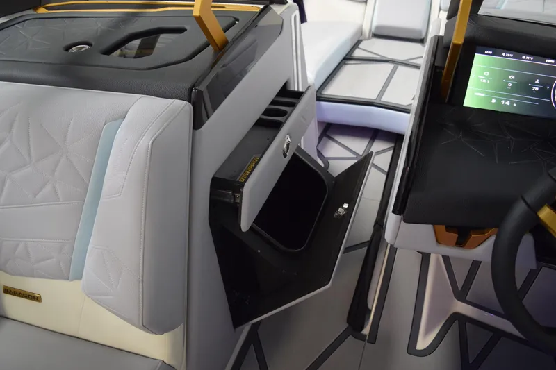 Slide: The Image of 2026 Nautique Super Air Nautique G25 Paragon interior with open storage compartment and modern dashboard. - 17