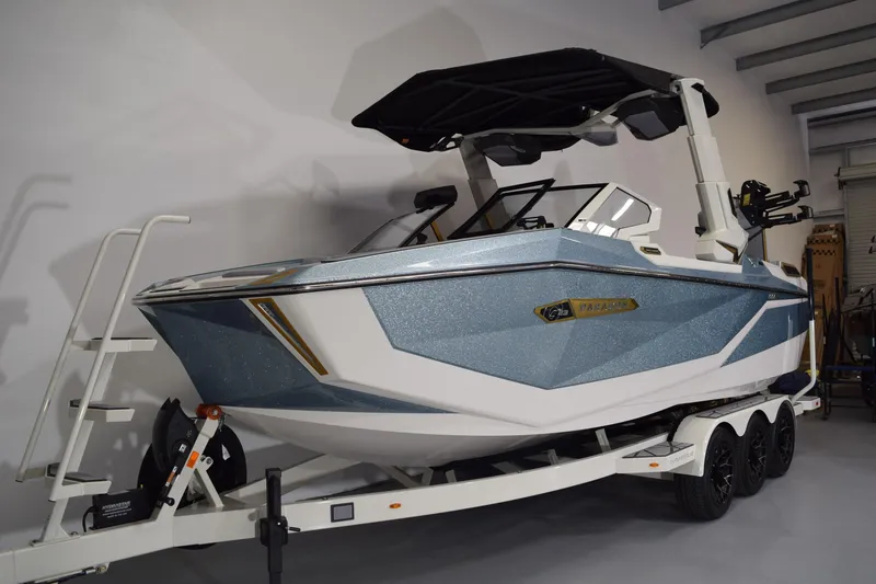 Slide: The Image of 2026 Nautique Super Air Nautique G25 Paragon boat on trailer in showroom. - 2