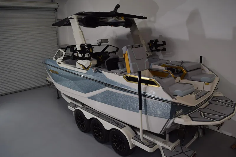 Slide: The Image of 2026 Nautique Super Air Nautique G25 Paragon boat in a garage on a trailer. - 3