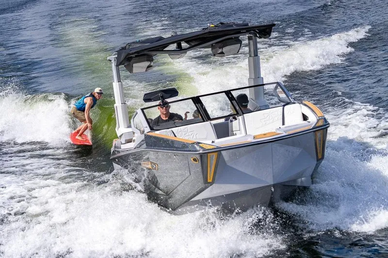Slide: The Image of Manufacturer Provided Image: 2026 Nautique Super Air Nautique G25 Paragon towing a wakeboarder on a sunny day. - 33