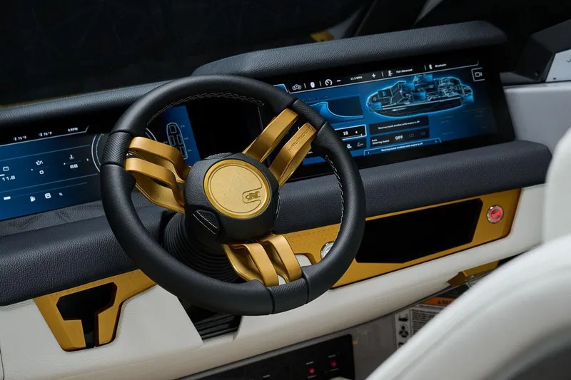 Slide: The Image of Manufacturer Provided Image: 2026 Nautique Super Air Nautique G25 Paragon dashboard with gold-accented steering wheel and digital display. - 39