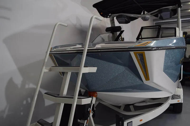 Slide: The Image of 2026 Nautique Super Air Nautique G25 Paragon boat in showroom with boarding ladder. - 6