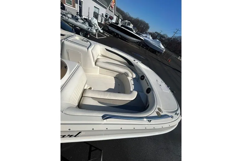 Slide: The Image of 2009 SouthWind 210 SD boat with spacious seating, parked outdoors on a sunny day. - 16