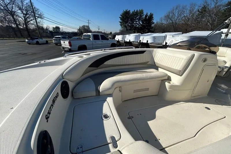 Slide: The Image of 2009 SouthWind 210 SD boat interior with white seating and dashboard in a parking lot. - 17