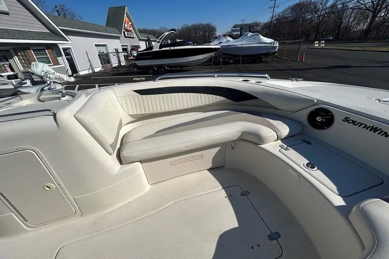 Slide: The Image of 2009 SouthWind 210 SD boat interior with white seating and dashboard in a marina setting. - 18