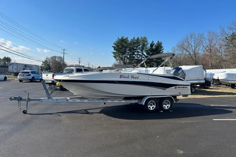 Slide: The Image of 2009 SouthWind 210 SD boat on trailer, labeled "Black Pearl," parked outdoors. - 8