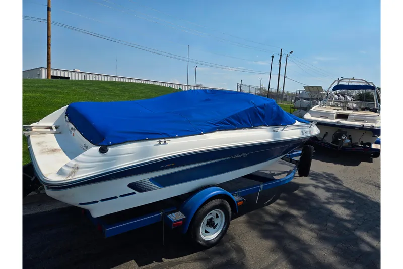 Slide: The Image of 1994 Sea Ray 180 Bow Rider boat with blue cover on trailer. - 1