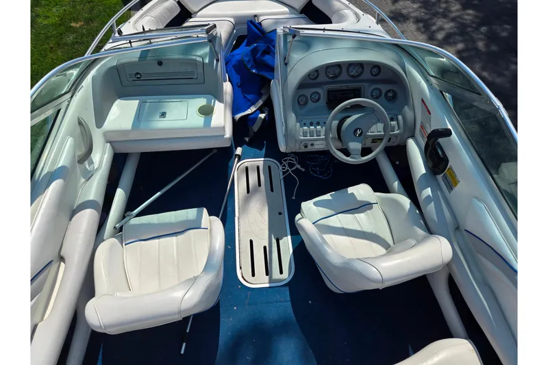 Slide: The Image of 1994 Sea Ray 180 Bow Rider interior with white seating and blue carpet. - 12