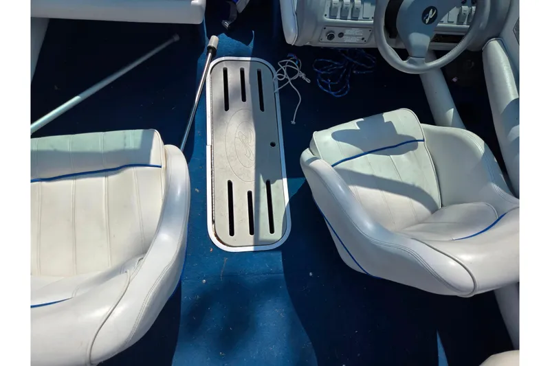 Slide: The Image of Interior of a 1994 Sea Ray 180 Bow Rider boat with white seats and blue carpet. - 13