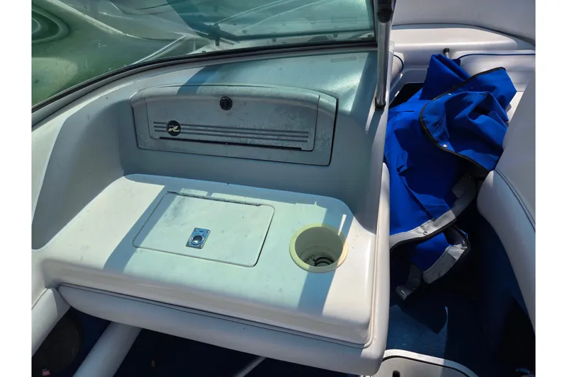 Slide: The Image of 1994 Sea Ray 180 Bow Rider interior with storage compartment and blue cover. - 16