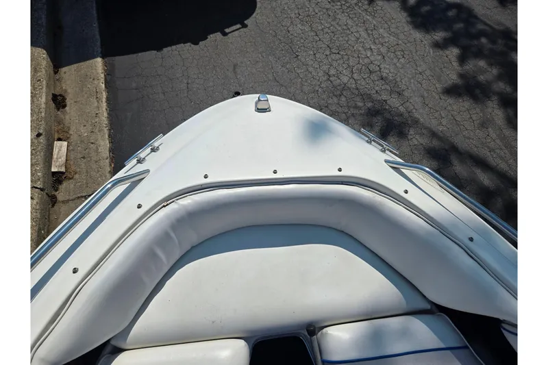 Slide: The Image of 1994 Sea Ray 180 Bow Rider boat bow with white seating and metal railings. - 18