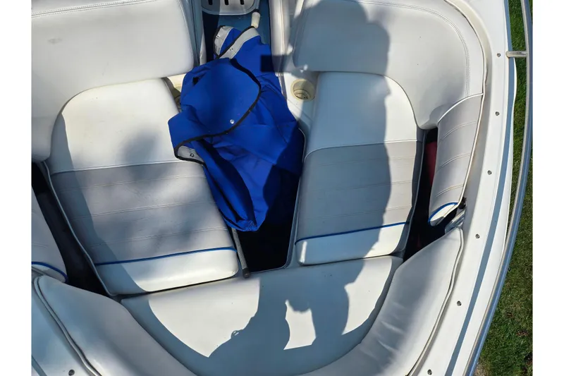 Slide: The Image of 1994 Sea Ray 180 Bow Rider interior with white seating and blue life jacket. - 19