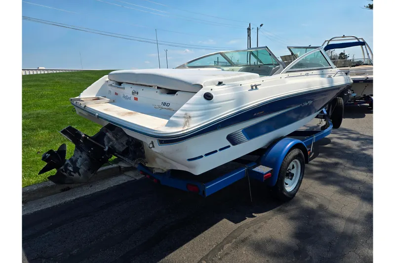 Slide: The Image of 1994 Sea Ray 180 Bow Rider boat on trailer, parked on a sunny day. - 4