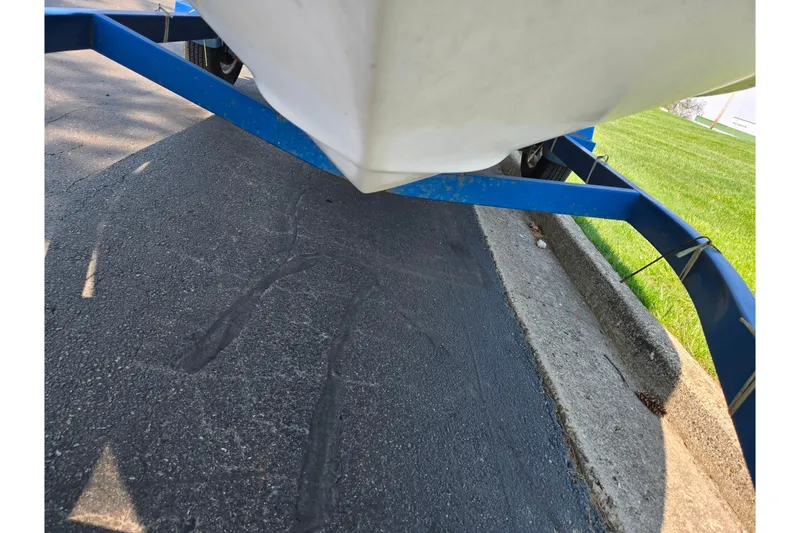 Slide: The Image of 1994 Sea Ray 180 Bow Rider on blue trailer, parked on asphalt near grass. - 8