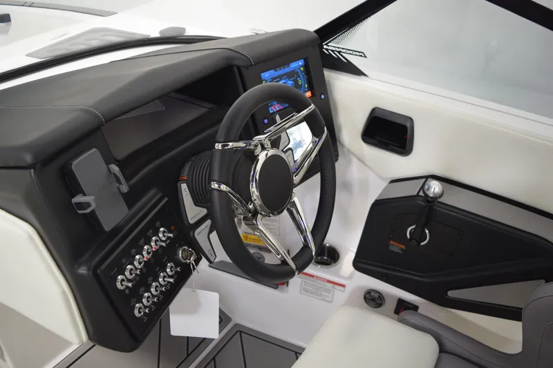 Slide: The Image of 2026 Moomba Tykon boat dashboard with steering wheel, control panel, and touchscreen display. - 28