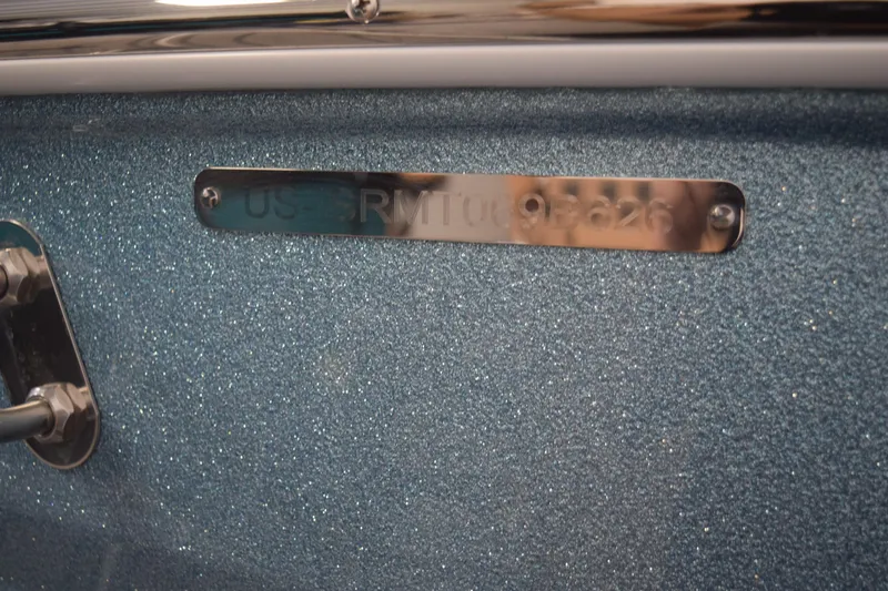 Slide: The Image of 2026 Moomba Tykon boat identification plate on a sparkling blue surface. - 32