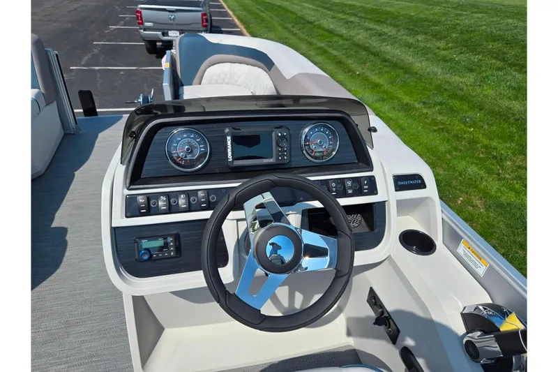 Slide: The Image of 2025 Godfrey Sweetwater 2286 QS boat dashboard with steering wheel and control panel. - 21