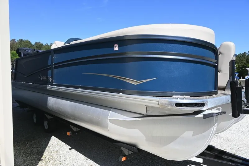 Slide: The Image of 2020 Premier 230 Sunsation RL - CL pontoon boat in blue, parked on a trailer. - 13