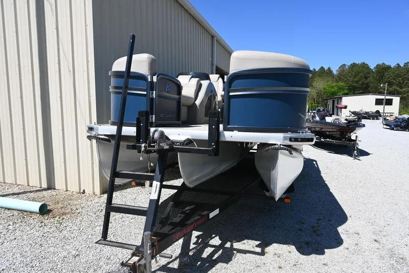 Slide: The Image of 2020 Premier 230 Sunsation RL - CL pontoon boat on trailer, parked outdoors. - 3