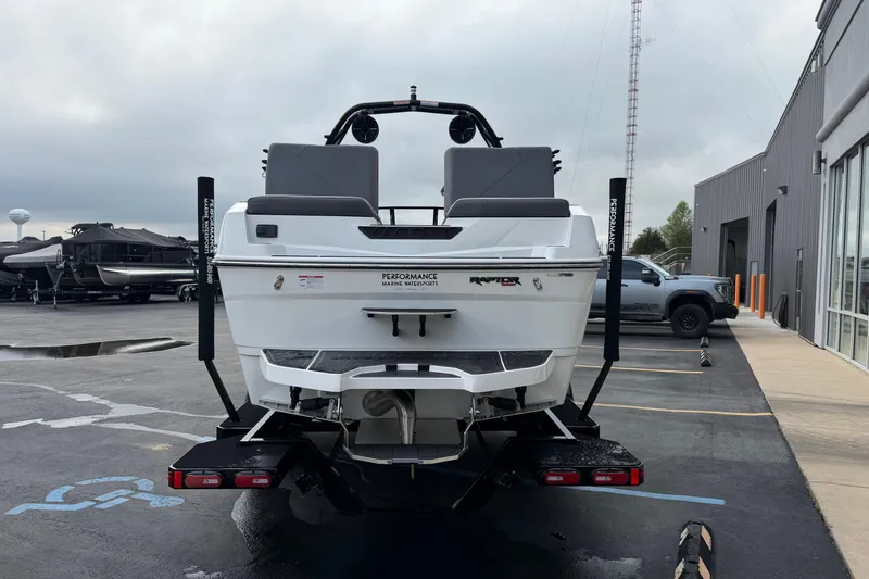 Slide: The Image of 2026 Moomba Tykon boat rear view in a parking lot, overcast sky. - 5