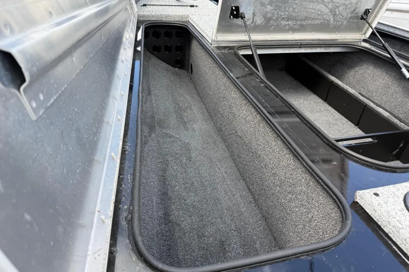 Slide: The Image of 2020 Tracker Pro Team 190 TX boat storage compartment, open and carpeted interior. - 29
